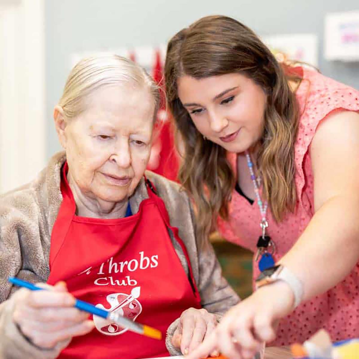 Resident and staff member engaged in an art activity