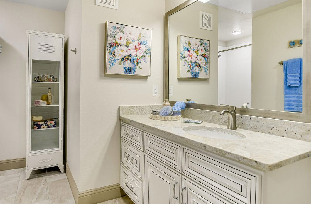 Bright bathroom with floral artwork and storage unit