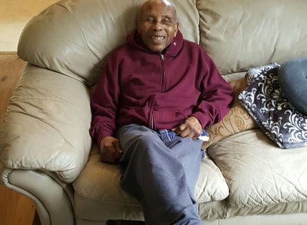 Resident relaxing on a couch in a common area
