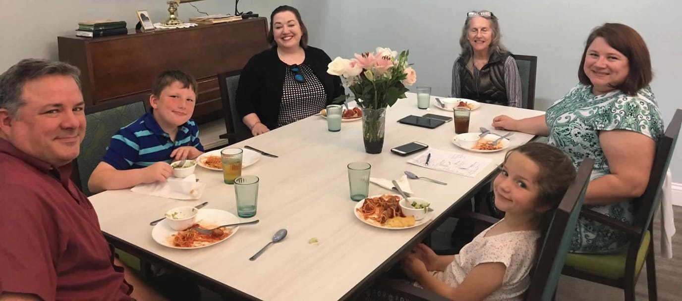 Residents and family enjoying a meal together in the dining area
