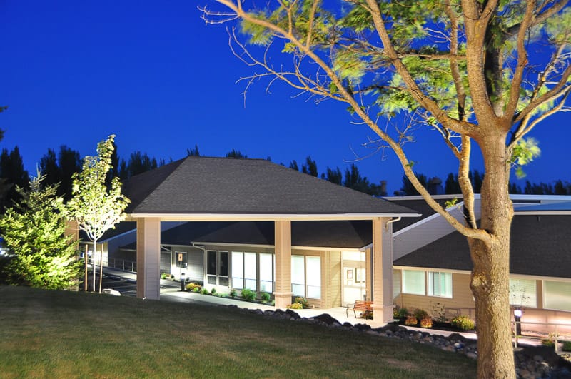 Exterior view of the facility at dusk with landscaping