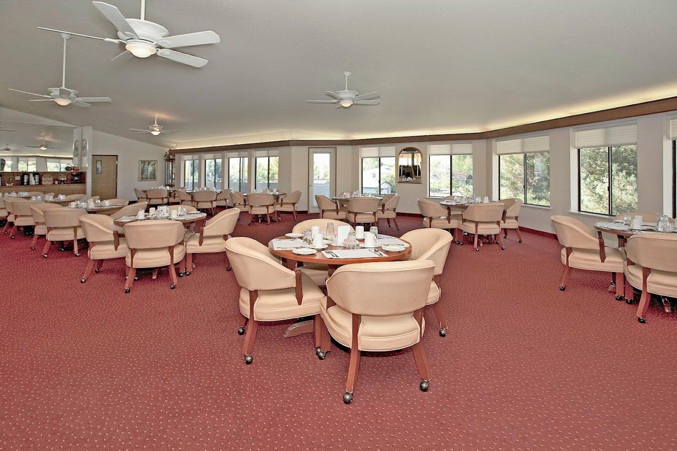 Spacious dining room with tables and chairs set for a meal.