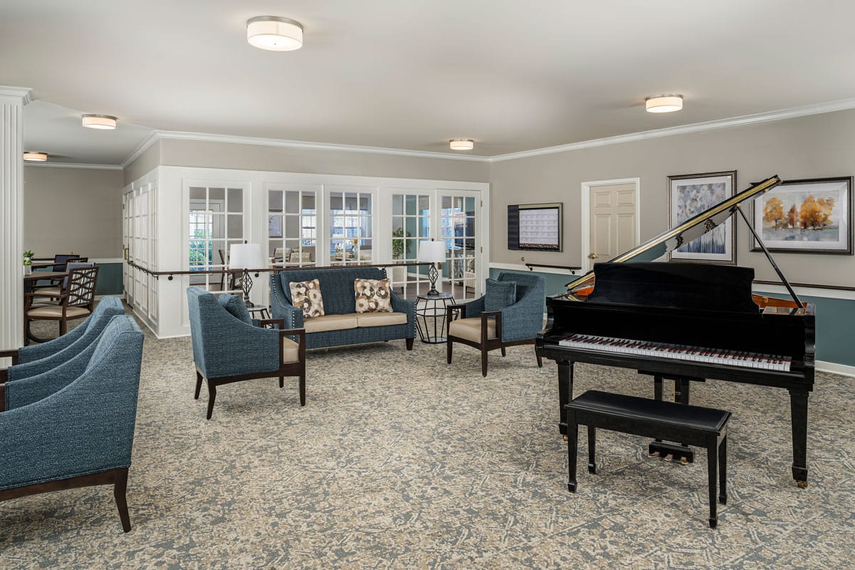Spacious living room featuring comfortable seating and a piano