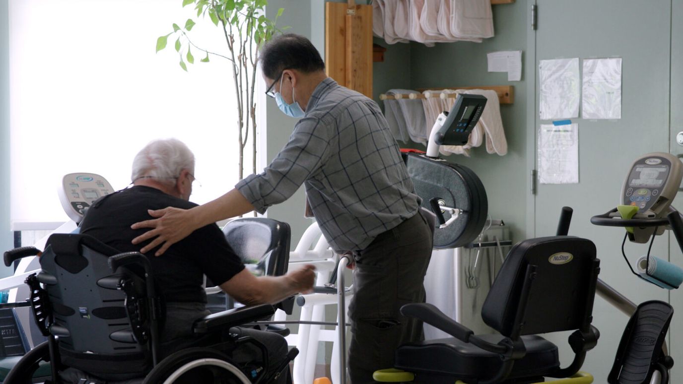 Staff assisting a resident in an activity room