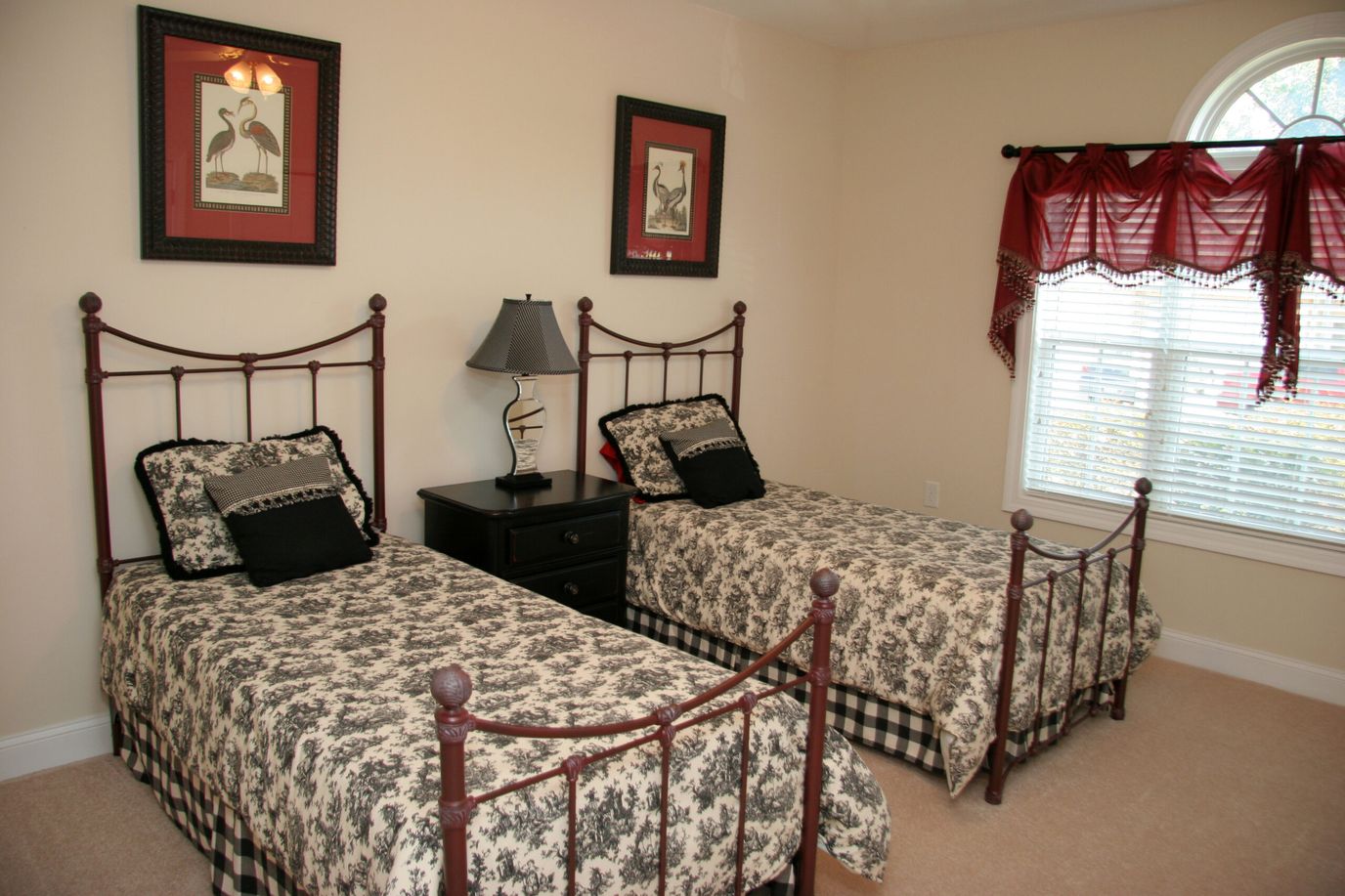 Two twin beds with floral bedding in a bright room.