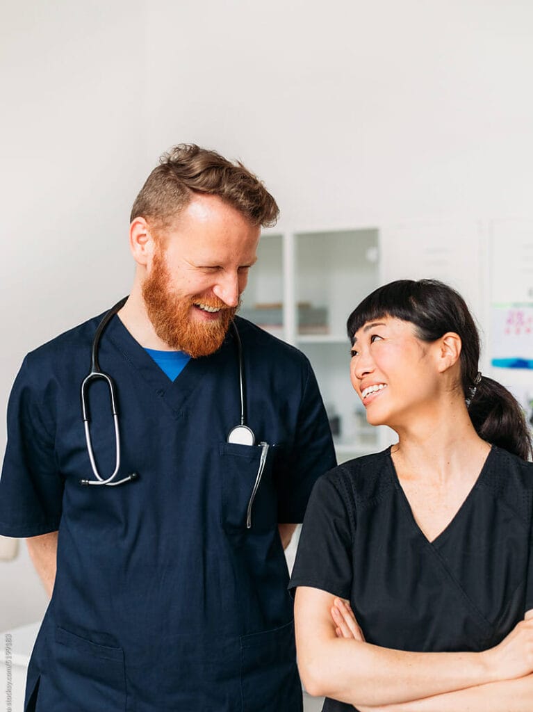 Two healthcare professionals smiling at each other