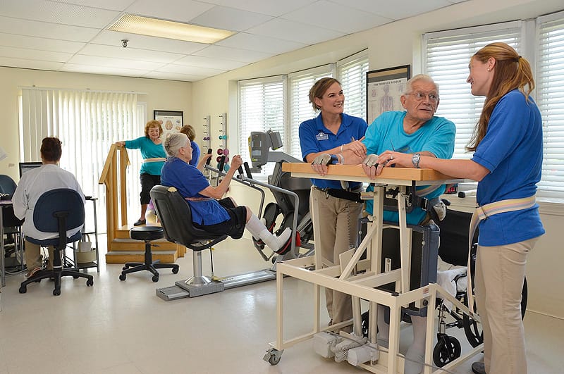 Staff assisting residents in a therapy room