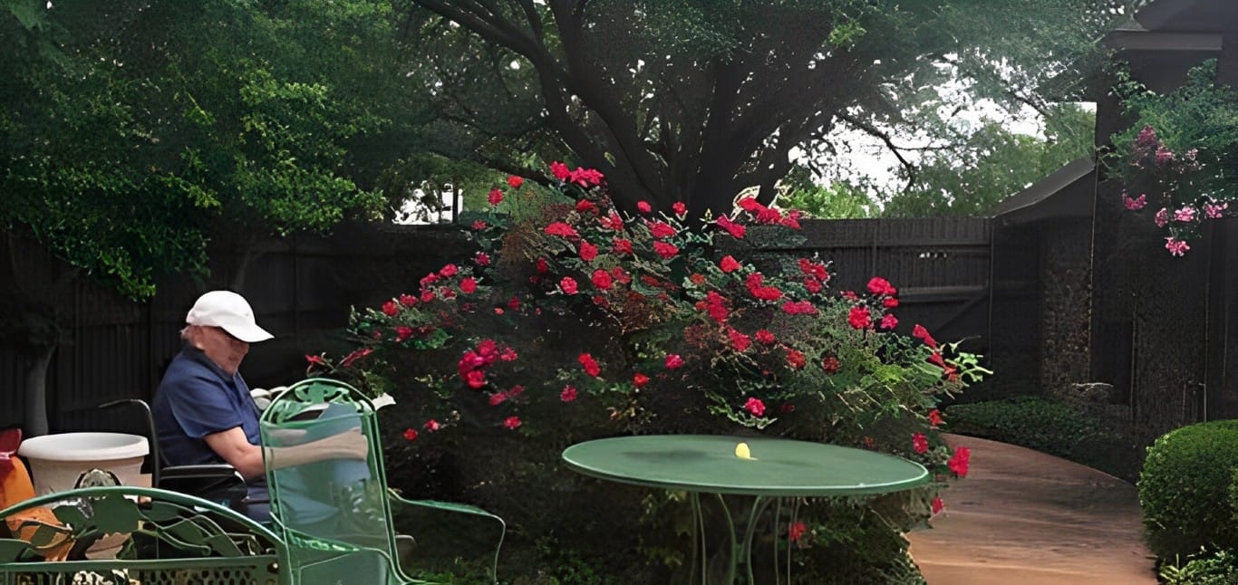 Senior resident enjoying the garden on a sunny day at The Heritage House of Garland.