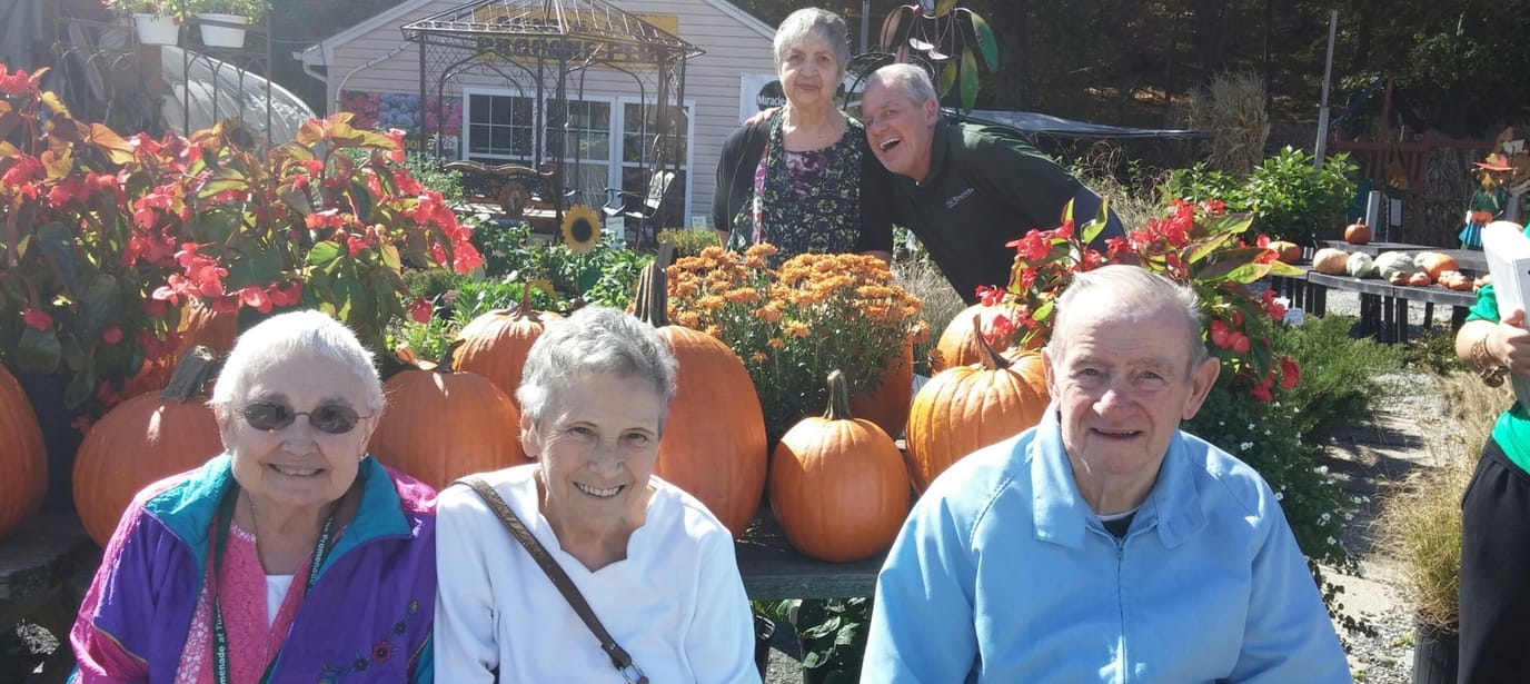 Residents enjoying a fall outdoor gathering with pumpkins