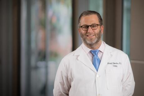 Doctor in a white coat smiling indoors