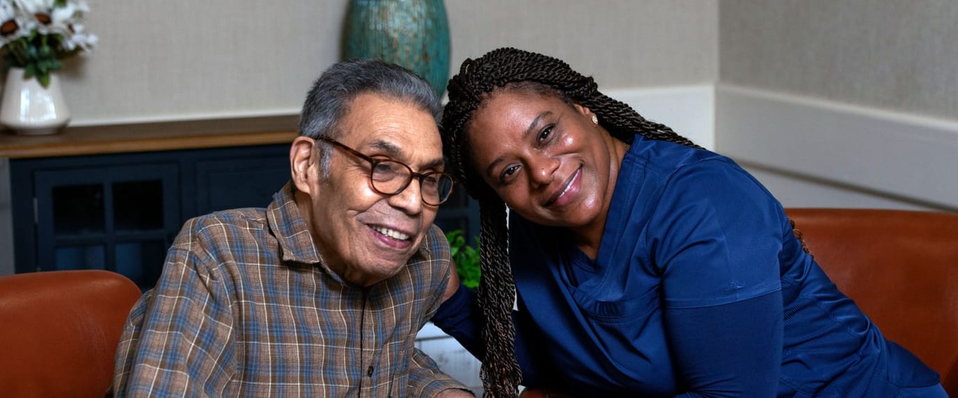 A resident and staff member smiling together in a common area
