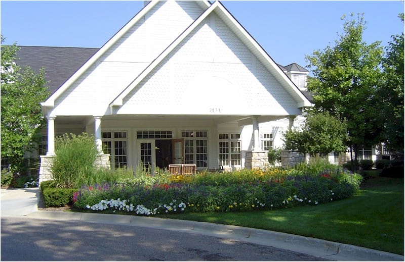 Main entrance of Heritage in the Hills with colorful flower beds