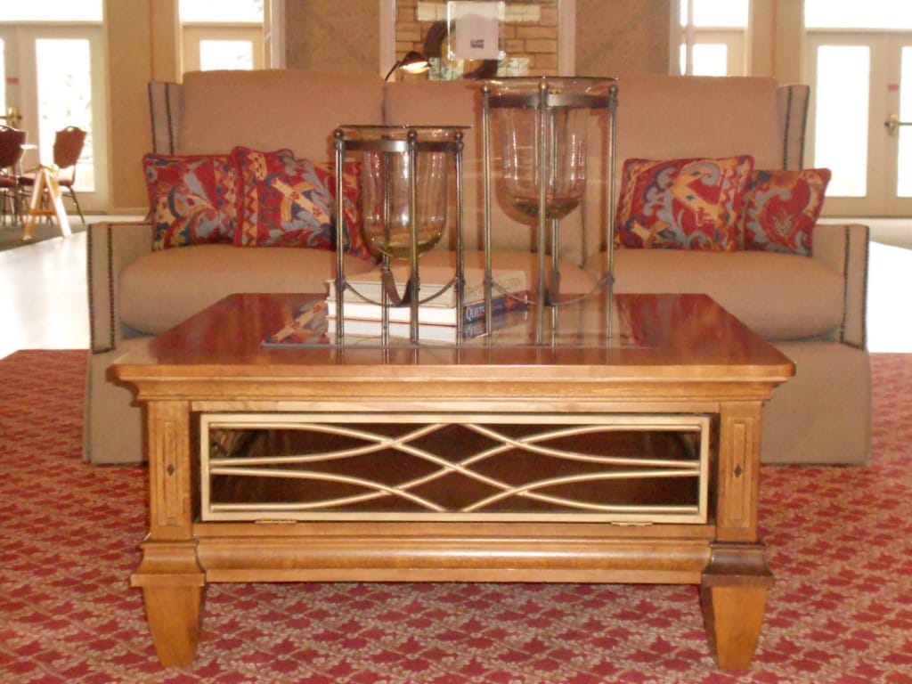 Wooden coffee table with decorative glass and books in a living room