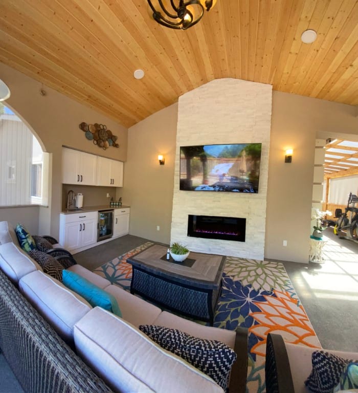 Bright and inviting living room with a stone fireplace and large TV