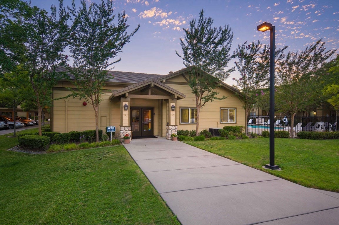 Main entrance of a senior apartment building with landscaped grounds