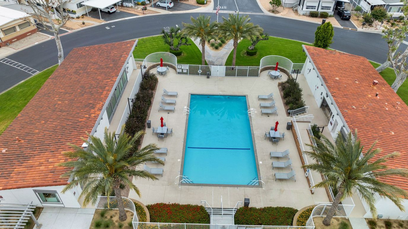 Aerial view of a community pool area with lounge chairs.