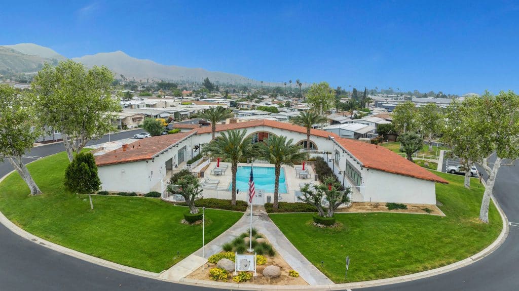 Aerial view of a senior living facility with a pool and landscaped grounds