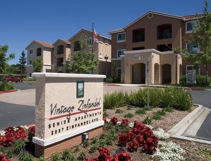 Entrance sign of Vintage Zinfandel Senior Apartments with colorful landscaping