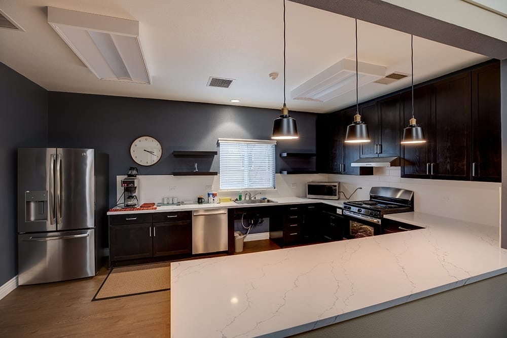 Kitchen with modern appliances and marble countertops.