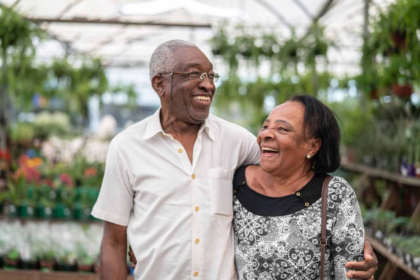 Happy couple smiling at a greenhouse
