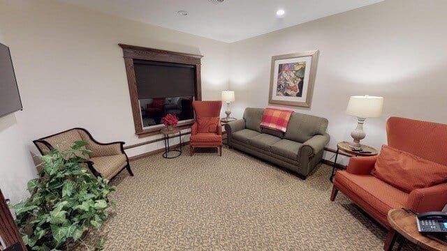 Comfortable living room with seating and a decorative window.