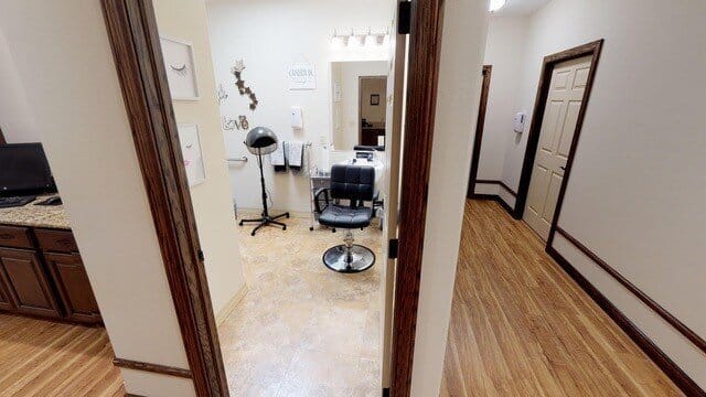 View of the salon area with a styling chair and mirror