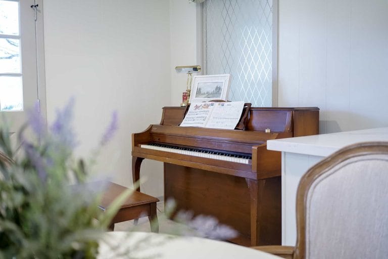 Wooden piano with sheet music in a cozy room