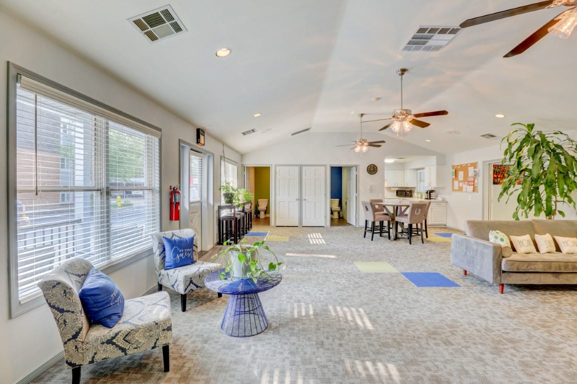 Inviting common area featuring chairs and tables with ample natural light.