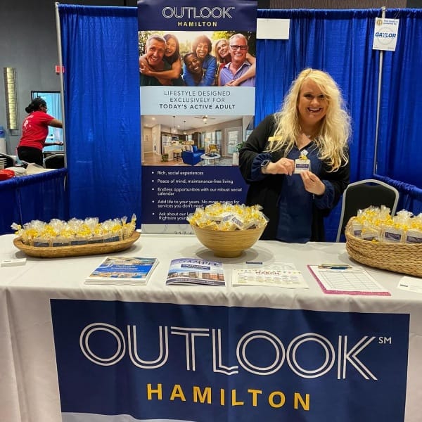 Staff member at Outlook Hamilton event table