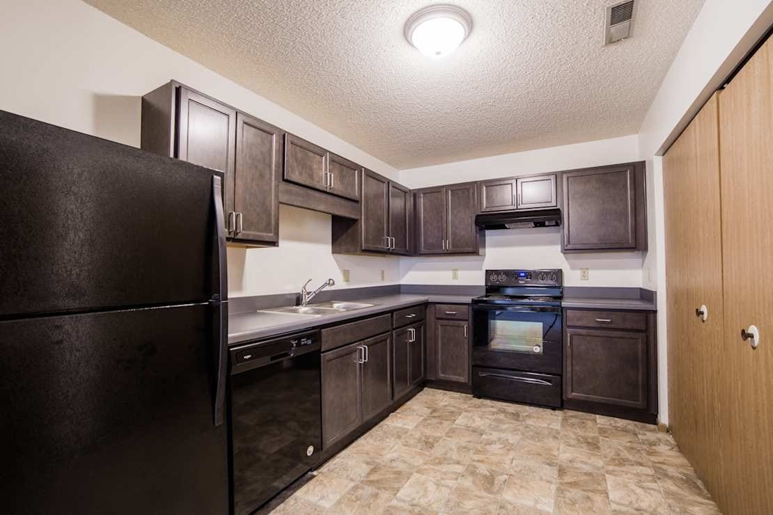 Spacious kitchen with dark cabinetry and appliances