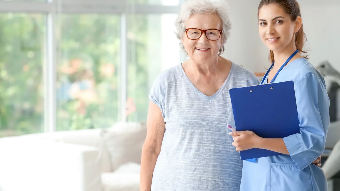 Smiling caregiver with senior resident indoors