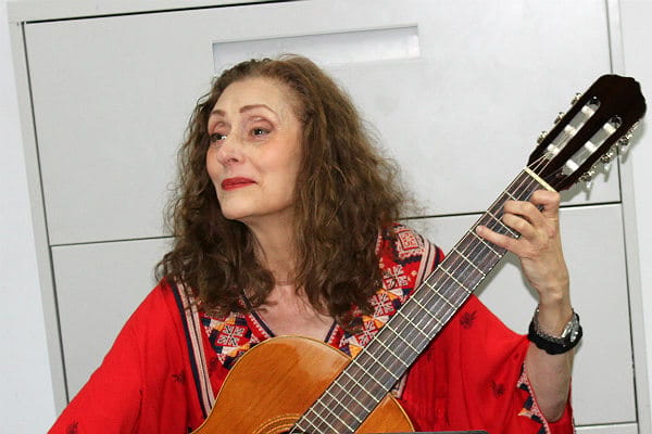 Woman playing guitar in a vibrant room