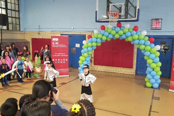 Children performing at a community event in a gym