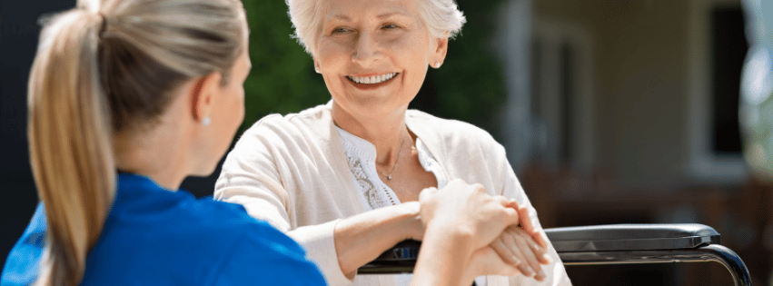 Senior resident chatting with staff outdoors