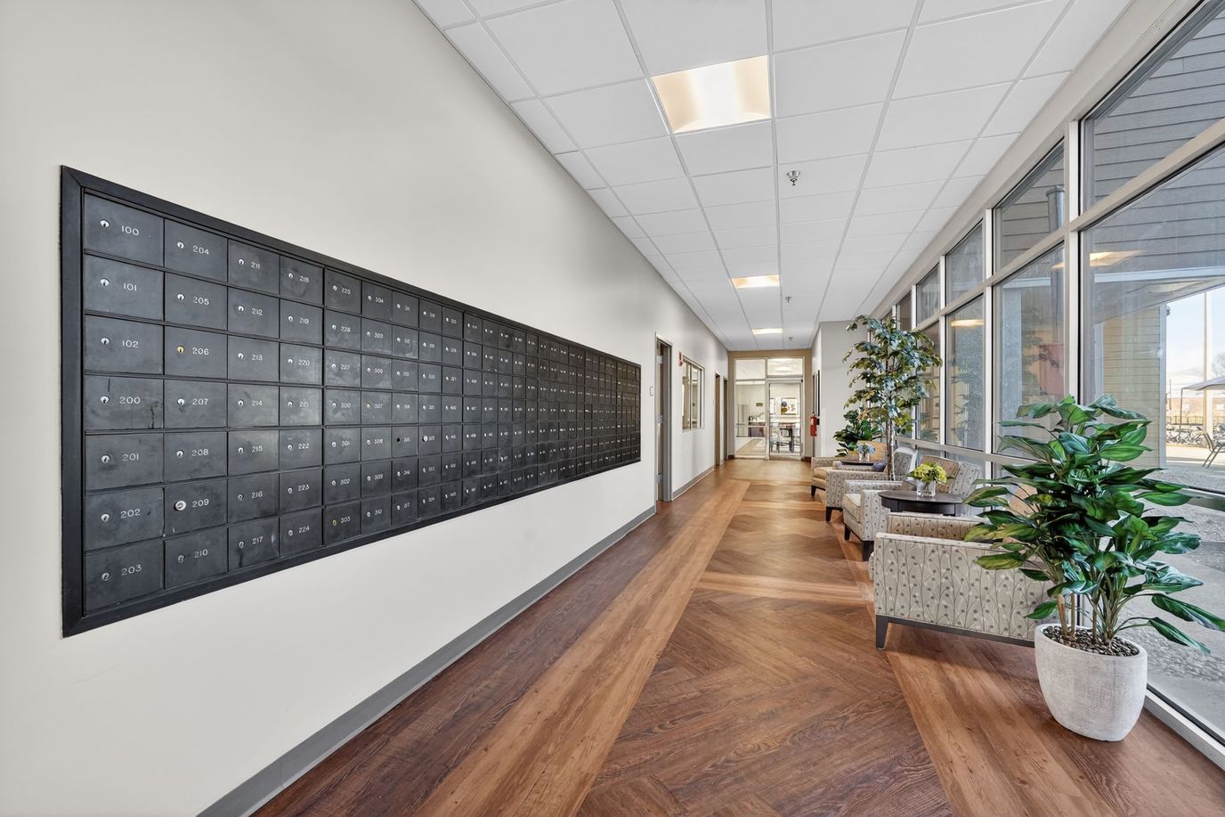 A well-lit interior hallway with mailboxes and seating