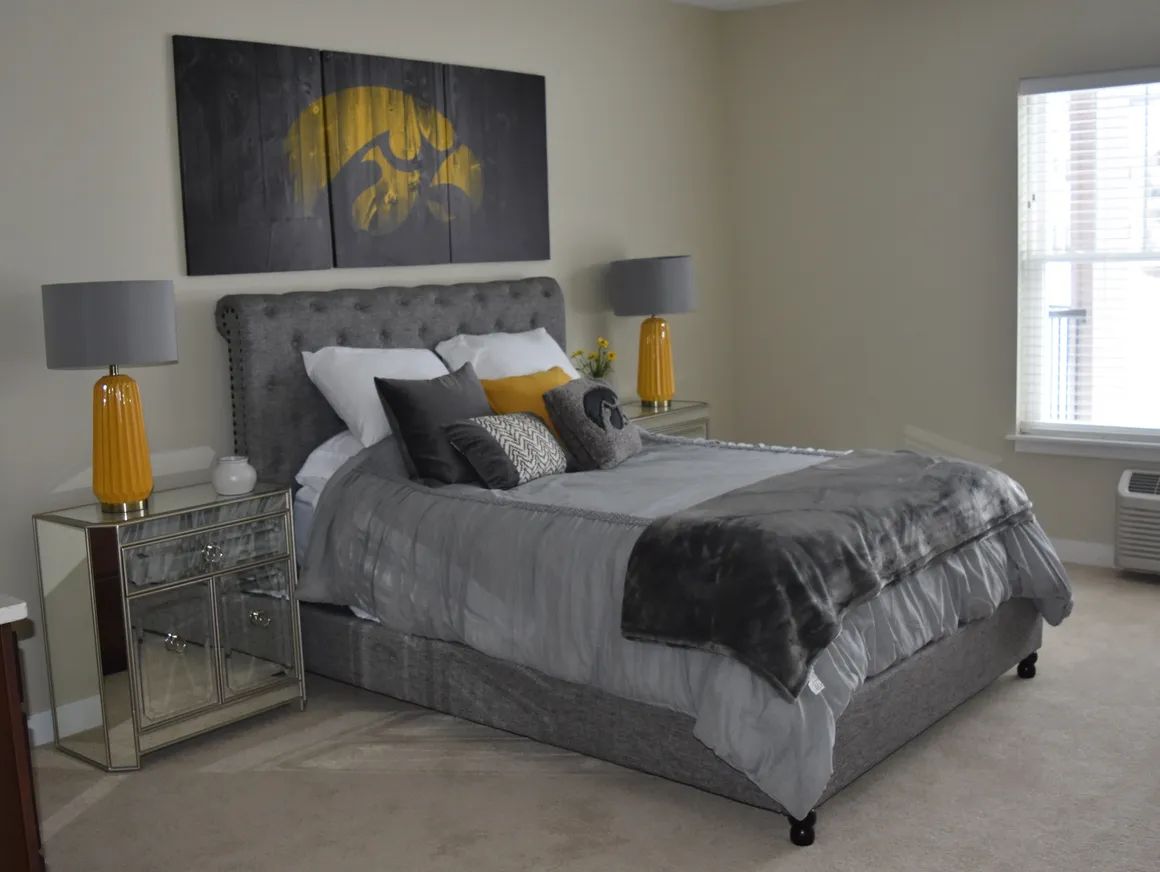 Stylish bedroom with a gray bed, decorative pillows, and a nightstand