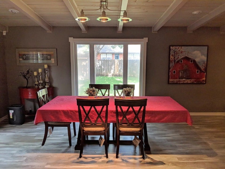 Interior view of a dining area with a red tablecloth and chairs.