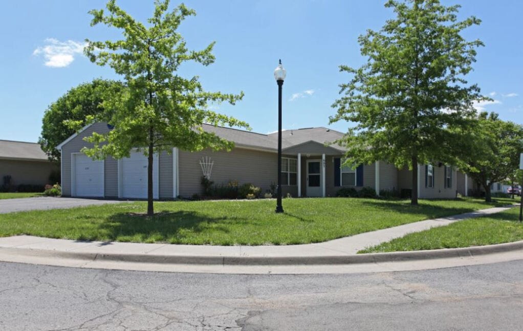 Exterior of Cottages of Topeka Senior Apartments with greenery and clear sky
