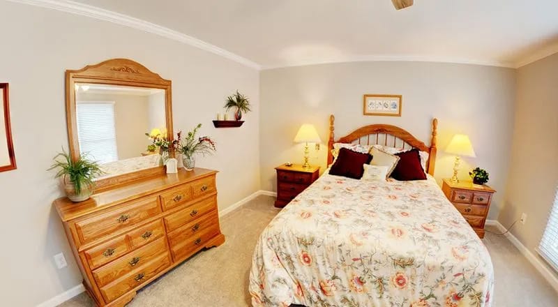 A comfortable bedroom with floral bedding and wooden furniture