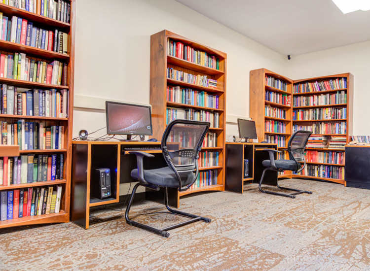 A cozy library area with computer stations and bookshelves