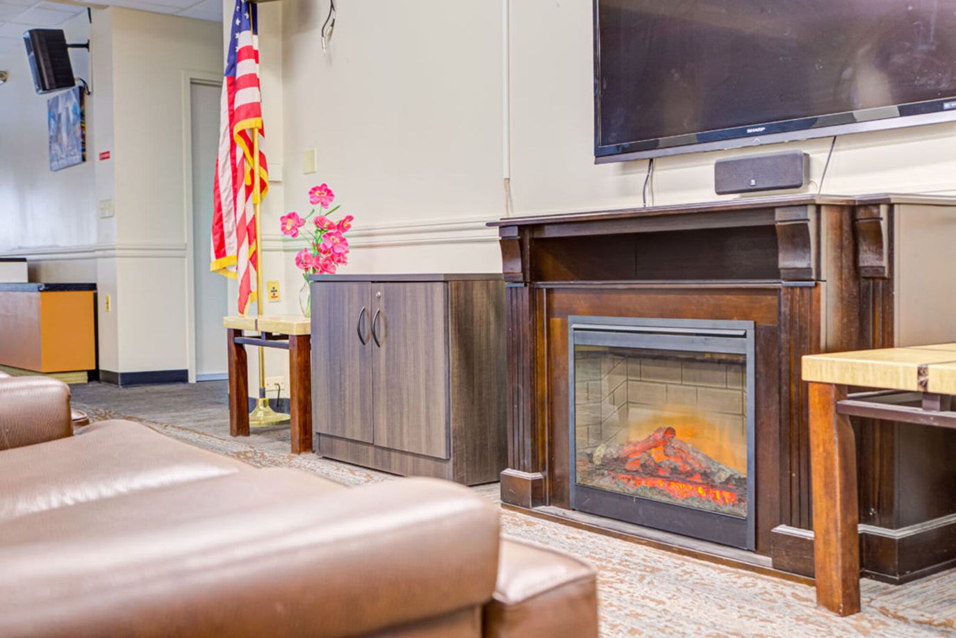 Cozy common area with a faux fireplace and seating