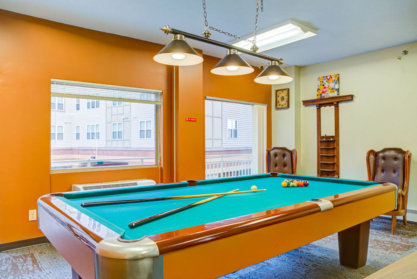 Billiard table in a recreational area with windows