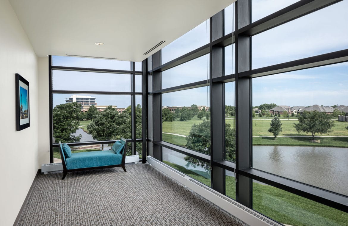 Lounge area with large windows overlooking a pond