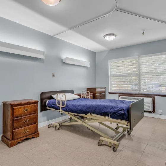 Private resident room with a hospital bed and dresser