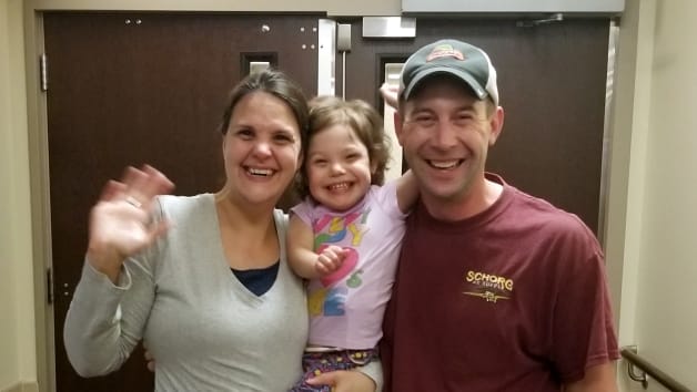 Family visiting a facility with smiling faces