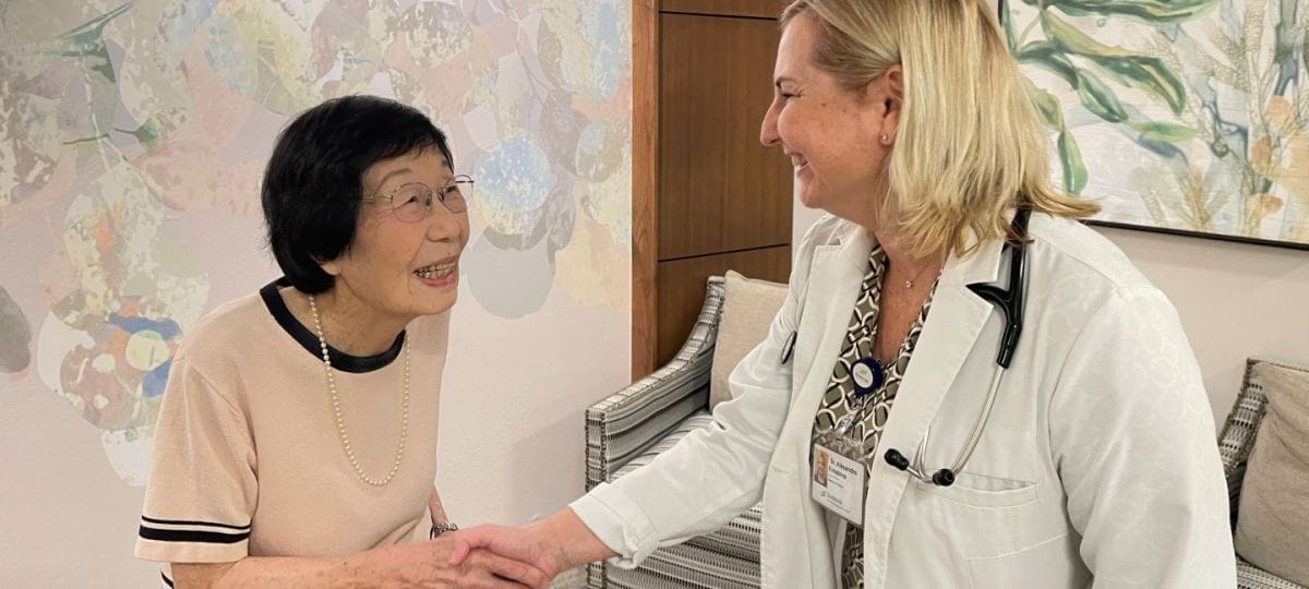 Staff member greeting a resident in a cozy common area