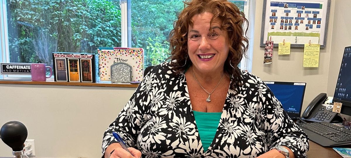 Staff member in an office smiling while working