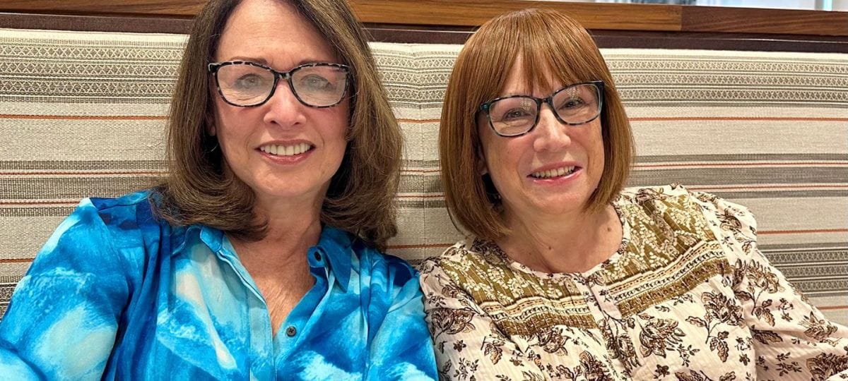 Two smiling women socializing in a comfortable setting