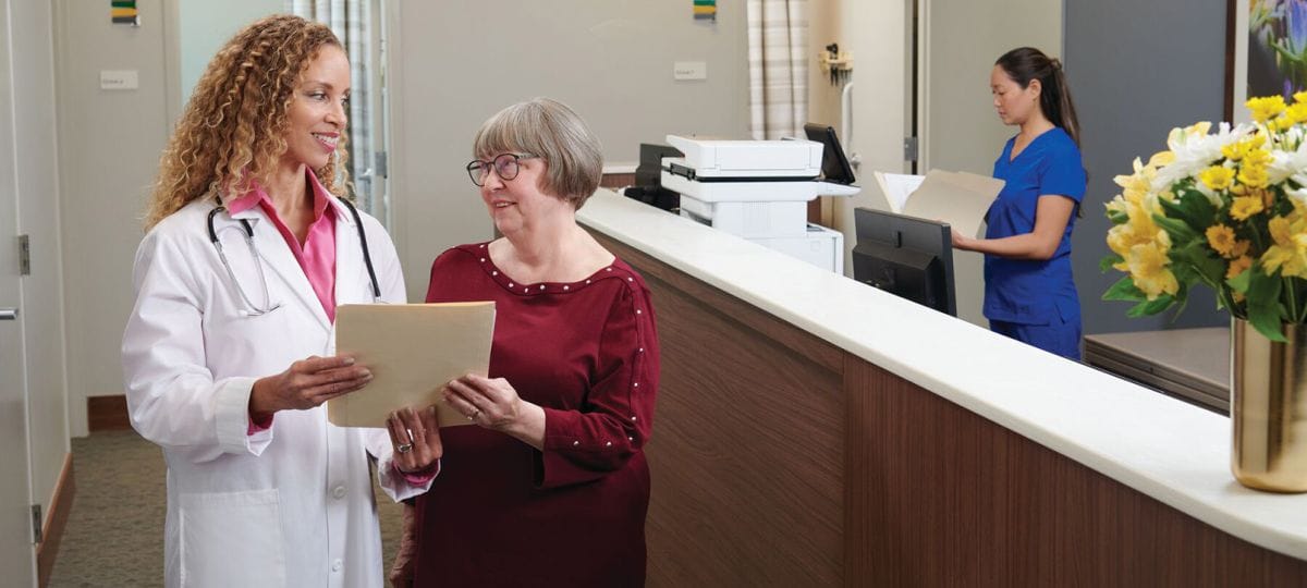 Healthcare staff interacting with a resident in the lobby