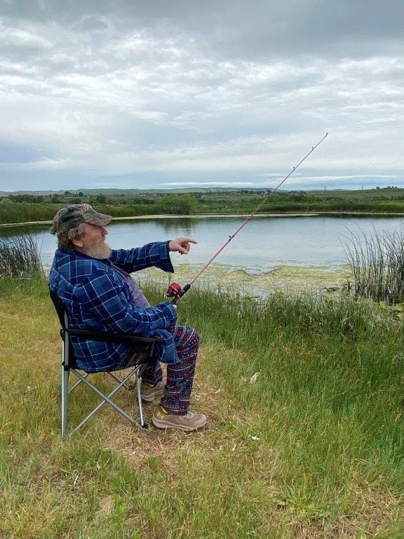 A man fishing by a peaceful lake